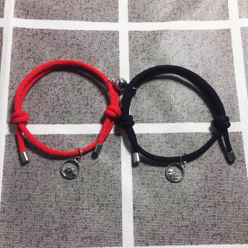 Two bracelets, one red and one black, on a checkered fabric background.